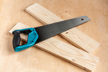 a saw on two wood boards on wooden background