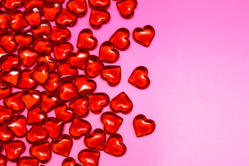 Small red hearts on a pink background. Love and celebration concept. Valentine's Day