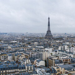 Fototapeta premium View on Eiffel tower over the roofs of Paris on a grey cloudy da