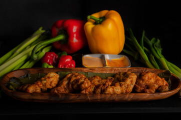 fried fish for a restaurant    menu or advertisement yellow pepper and red pepper and scotch bonnet pepper on the side