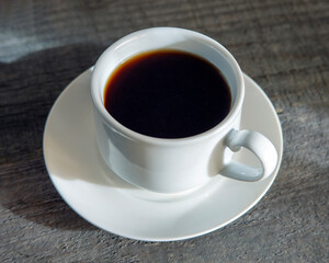 white cup with tea on a wooden table top