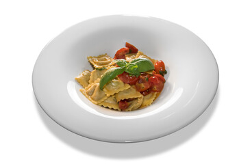 ravioli pasta with tomato sauce and sliced cherry tomatoes and basil leaves in white plate isolated on white background