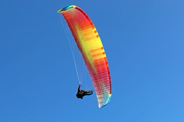 Paraglider flying wing in a blue sky	