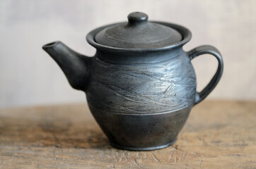 A table on which there is a mug of tea and a kettle.