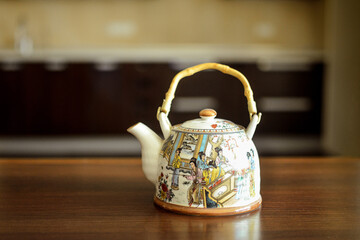 A table on which there is a mug of tea and a kettle.