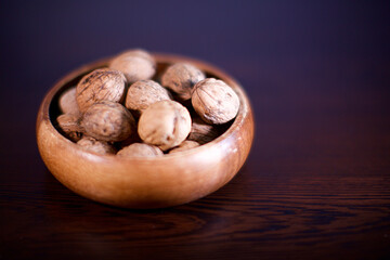 shelled walnuts in a wooden bowl. Blurry background.