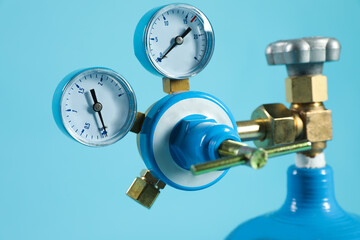 Pressure gauge of medical oxygen tank on light blue background, closeup