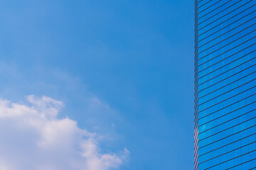 Fototapeta na wymiar Blue sky with cloud and modern blue office building.