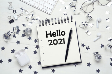 Hello 2021 . Flat lay composition with notebook on white wooden table