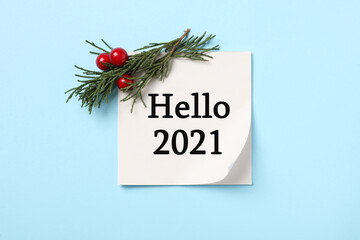 Memory sticker with text Hello 2021, thuja branch and red berries on light blue background, flat lay