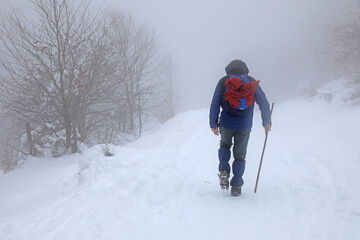 senderista montañero con grampones en la nieve niebla  país vasco 4M0A7290-as21