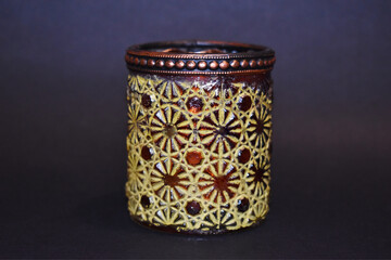 glass candle holder with geometric engraving texture on dark background
