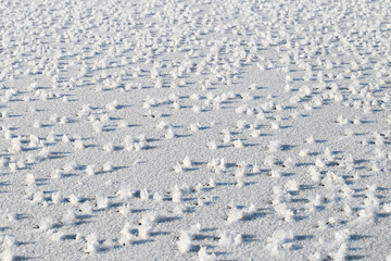 White ice shapes close up on snow background