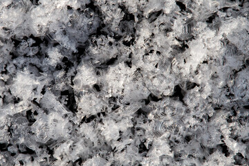 White ice patterns close up on a black background