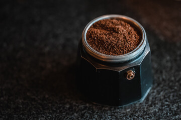 Moka coffee pot filled with brown ground coffee to prepare traditional Italian espresso