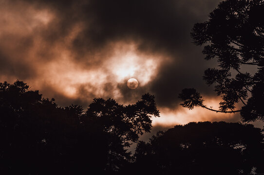 lindo por do sol com nuvens de chuva, dando um tom de escurid&atilde;o