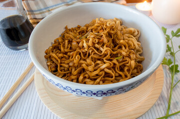 Oriental food, Chinese noodles, picked up with wooden chopsticks