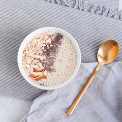 Healthy breakfast fruit smoothie bowl topped with almond, granola and chia seeds, snack banana and blueberry, flat lay
