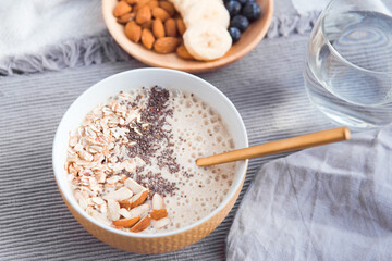 Healthy breakfast fruit smoothie bowl topped with almond, granola and chia seeds, snack banana and blueberry