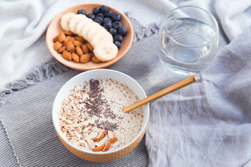 Healthy breakfast fruit smoothie bowl topped with almond, granola and chia seeds, snack banana and blueberry
