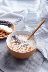 Healthy breakfast fruit smoothie bowl topped with almond, granola and chia seeds, snack banana and blueberry