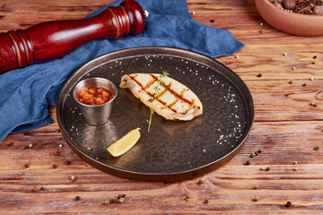 Grilled squid with sauce, wooden background