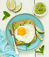 Toast with guacamole and egg for breakfast. Selective focus