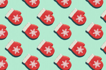 Creative Christmas pattern. Red mitten with snowflake over light green background. Creative Christmas pattern. Top view. Good for wallpaper, textile, background, poster, cover of book, post cards.