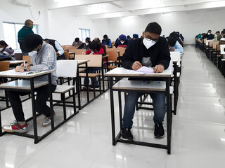 December 8, 2020.Lucknow Uttar Pradesh,India. West Bengal India. Medical students writing examination paper in mask maintaining social distancing at Radheshwam Medical College,Lucknow, UP, India