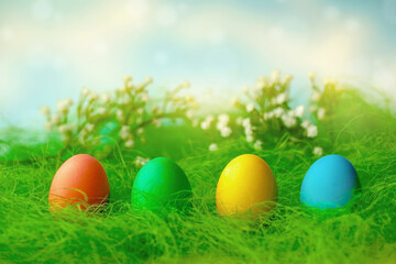 Happy Easter. A row of decorative multicolored Easter eggs on the green grass.