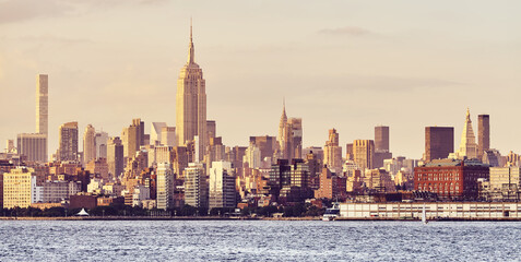 New York City skyline at golden sunset, color toned picture, USA.