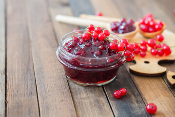 Red currant jam with red currants fresh berries on a wooden background
