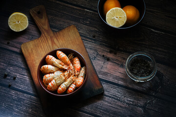 Greenlandic shrimps. Boiled shrimp on a dark background with lemon and spices.Preparation of a dietary dish . Protein products. Source of omega 3 and omega 6 acids.