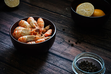 Greenlandic shrimps. Boiled shrimp on a dark background with lemon and spices.Preparation of a dietary dish . Protein products. Source of omega 3 and omega 6 acids.