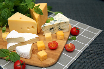 Mix the cheese on a wooden board with the grapes and cherry tomatoes. The view from the top.