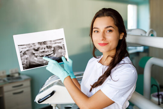 Close up woman dentist holding patient mouth digital film.The dentist explained about the oral cavity to the patient at the dental office