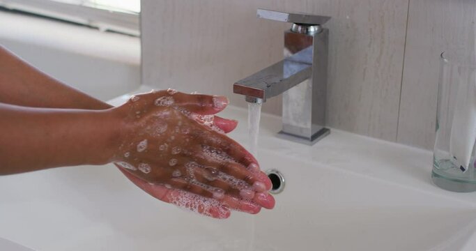 Close up of african american woman washing her hands in the bathroom sink at home