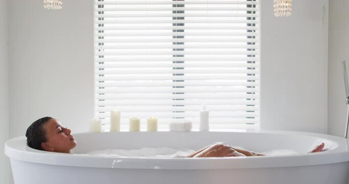 African american woman bathing in the bath tub in the bathroom at home
