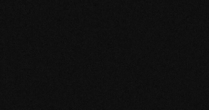 Animation of dark grey abstract noise specks moving fast on dark grey background
