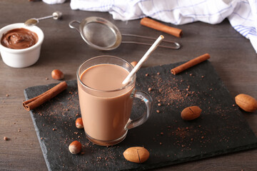 Cup of cocoa with straw on a dark wooden background