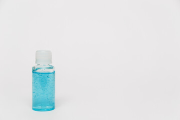 Alcohol sanitizing gel blue color in small bottle on the white background. Small bottle of shampoo or shower gel. Coronavirus personal protective equipment. PPE concept in 2021