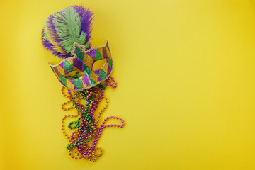 Mardi gras or carnival mask with beads on yellow background. Venetian mask. © vetre