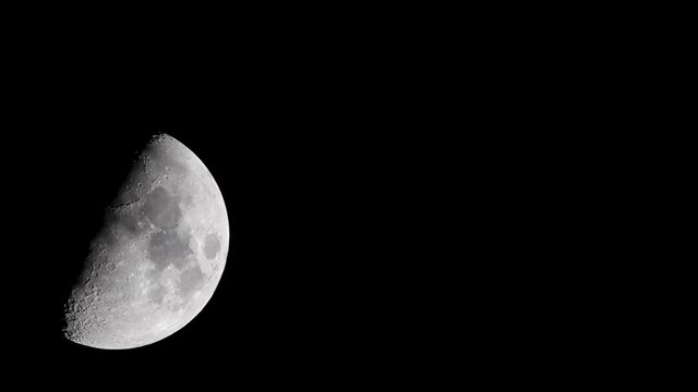 Waxing gibbous phase moon moving in dark night sky. Craters, sea of tranquality and details are visible. sky is clear.