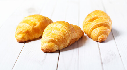 Fresh croissants on a white background,  Food and breakfast concept, puff pastry and biscuits on wooden table.