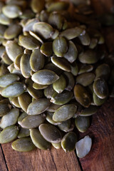 Fresh pumpkin seeds on wooden background. Peeled pumpkin seeds. Food background.