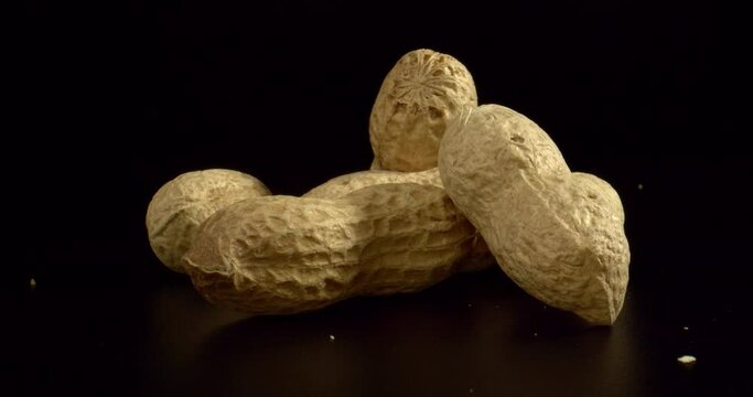 Raw Peanuts isolated on black background, close up. Peanuts for a snack. Organic peanuts. Food with vitamins and omega 3 fatty acids. Zoom out. High quality.