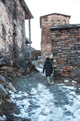 A young woman moves on the streets of Ushguli village in the winter in Georgia