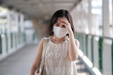 Asian girl with face mask feeling dizziness and headaches