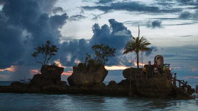 Time lapse view of tourists taking photos on natural landmark Willy's Rock on Boracay Island, Western Visayas, Philippines. 