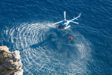 Brandweerhelikopter verzamelt water over zee
